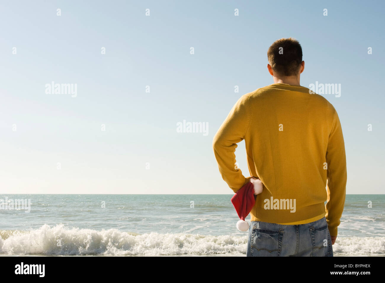 Young man at beach looking at view Stock Photo