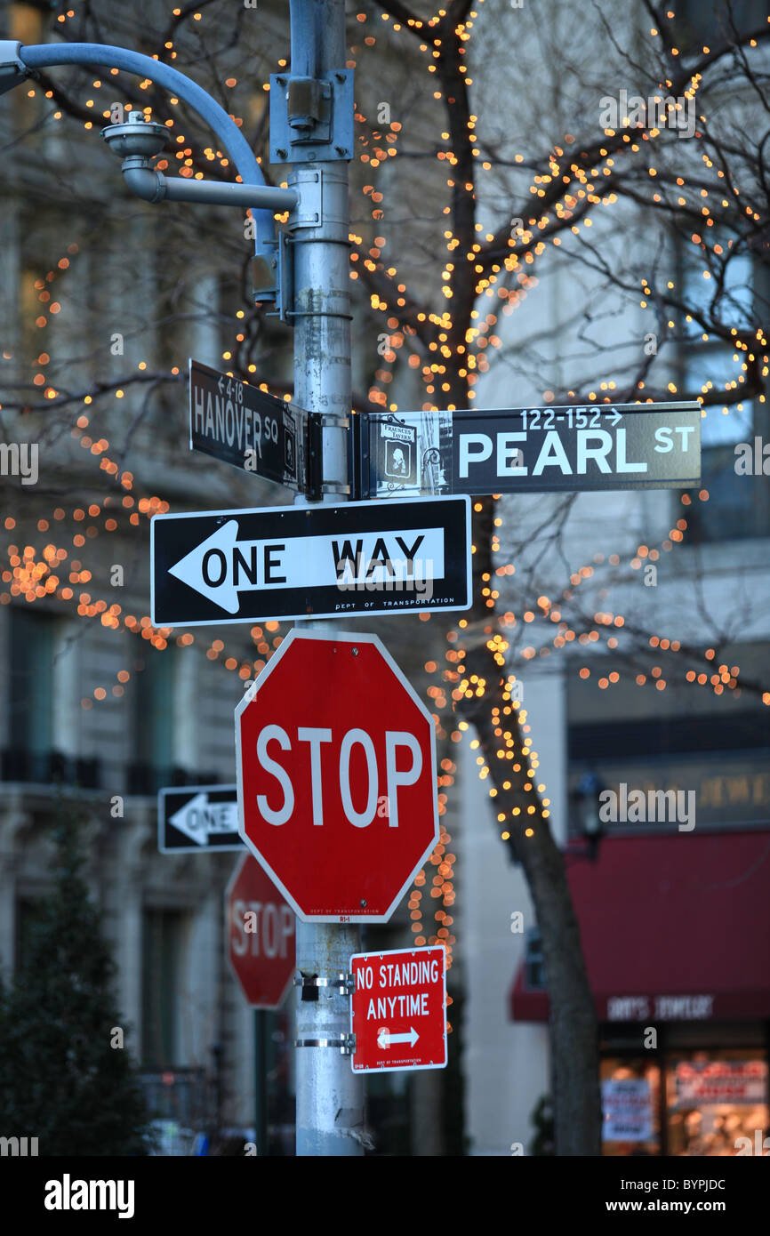 Stop sign and oneway sign at an intersection at Pearl St in New York