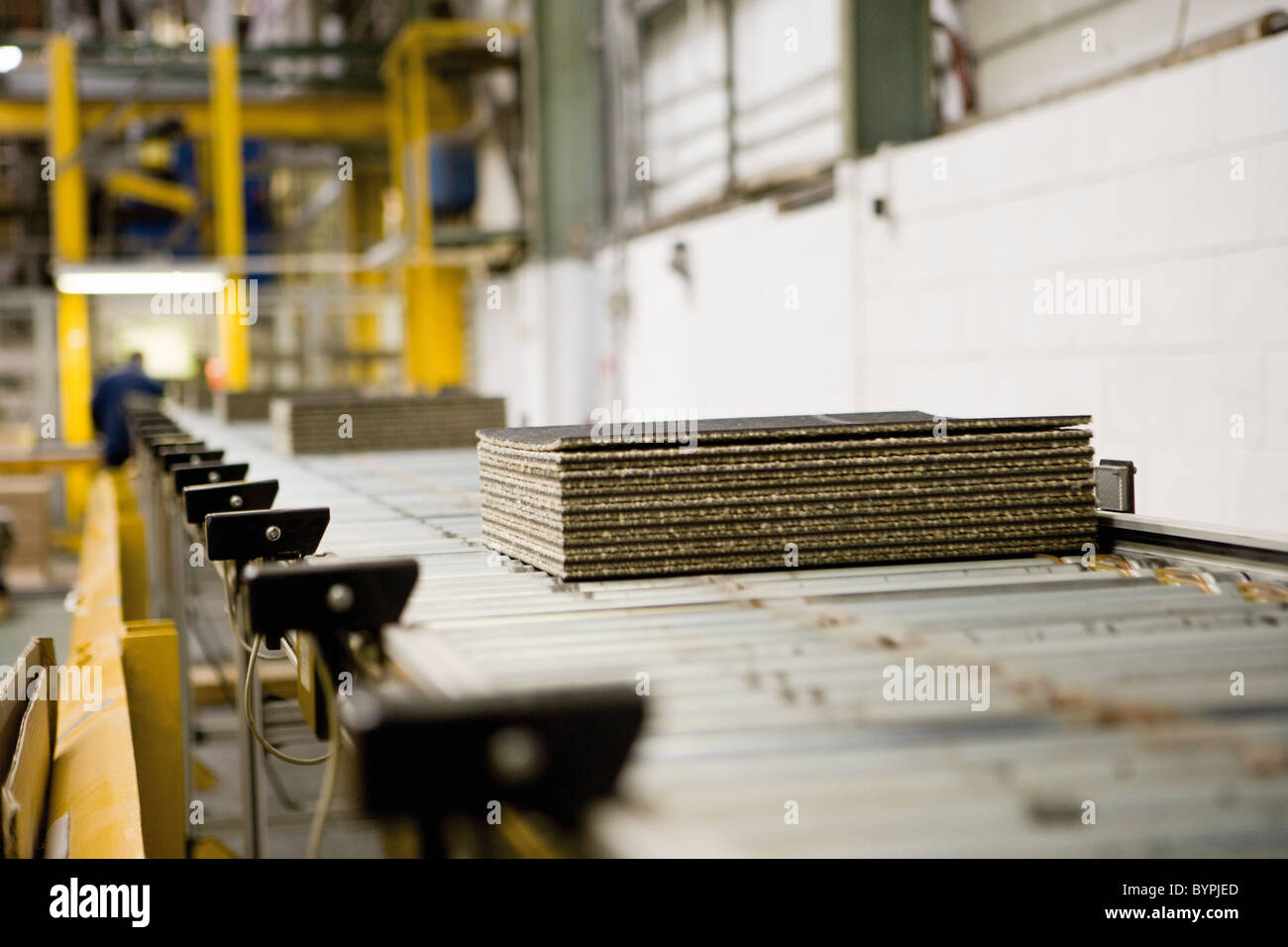 Piled carpet tiles on an automatic roller conveyor with detection cells
