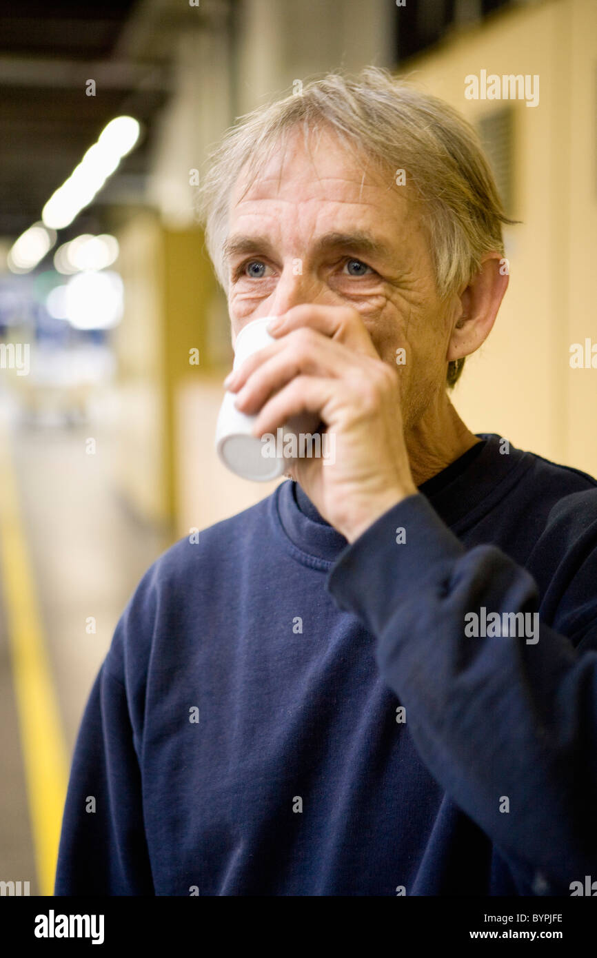 Factory worker drinking cup of coffee Stock Photo - Alamy