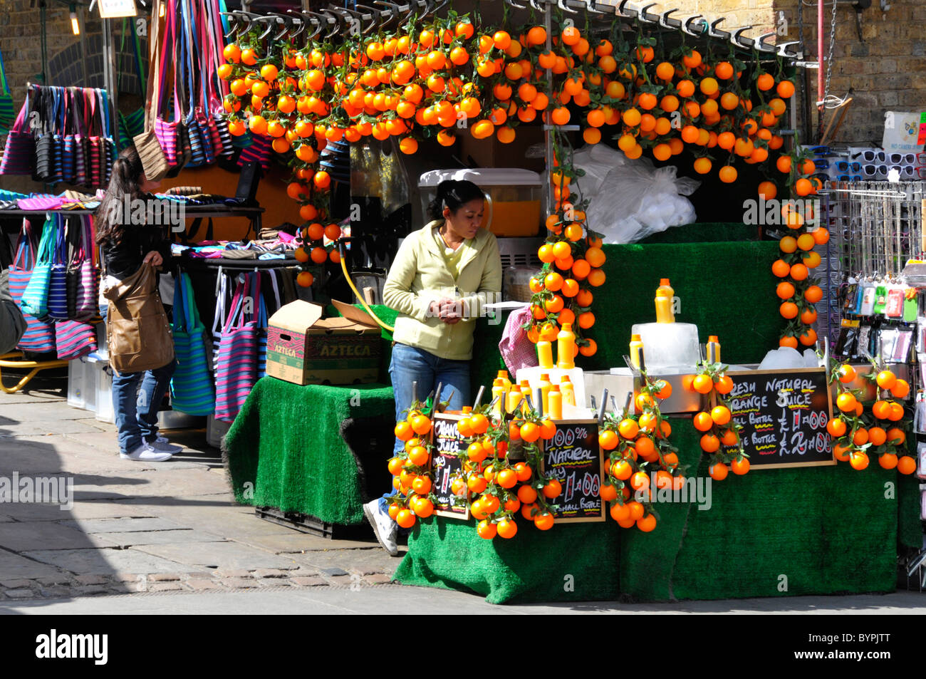 Stall at Camden Market selling natural orange juice drinks on a hot