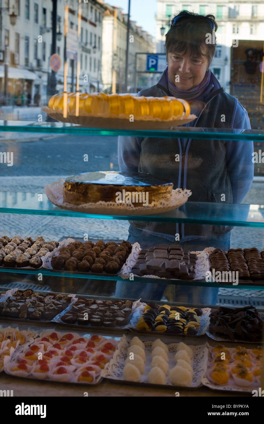 Tourist admires sweets in window of Confeitaria Nacional a cake shop in Praça da Figueira, Lisbon, Portugal Stock Photo