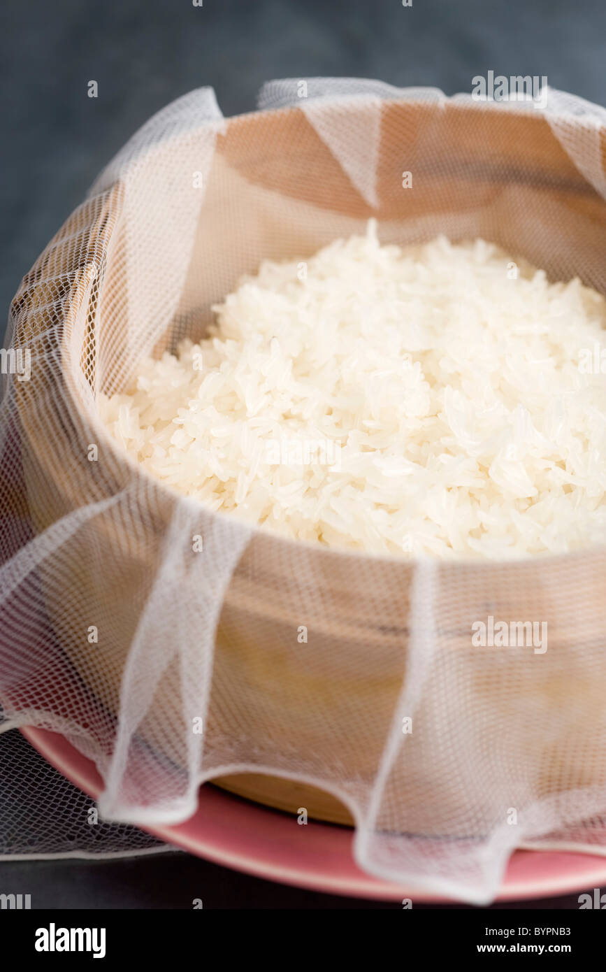 Sticky rice steaming in bamboo baskets over a taoloh at the