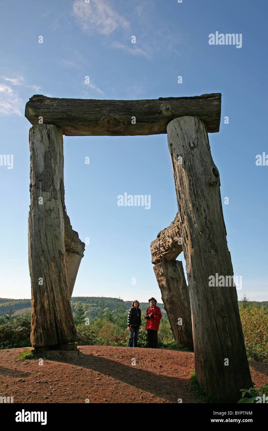 Two people looking at an outdoor sculpture works of art in the Forest of Dean Monmouth Wales Stock Photo