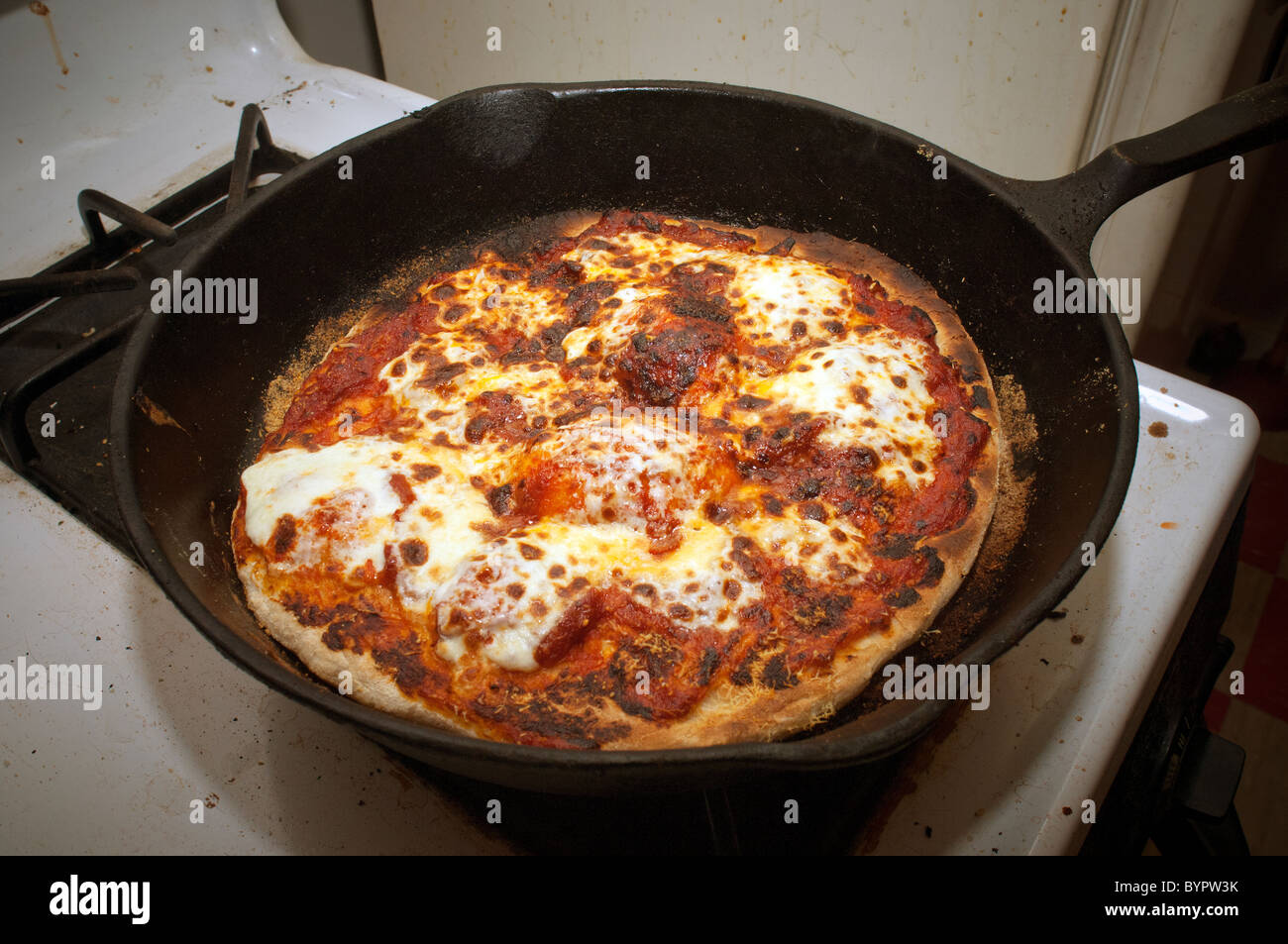 A homemade pizza pie made in a cast iron pan is seen on a kitchen stove on Sunday, January 30, 2011. (© Richard B. Levine) Stock Photo