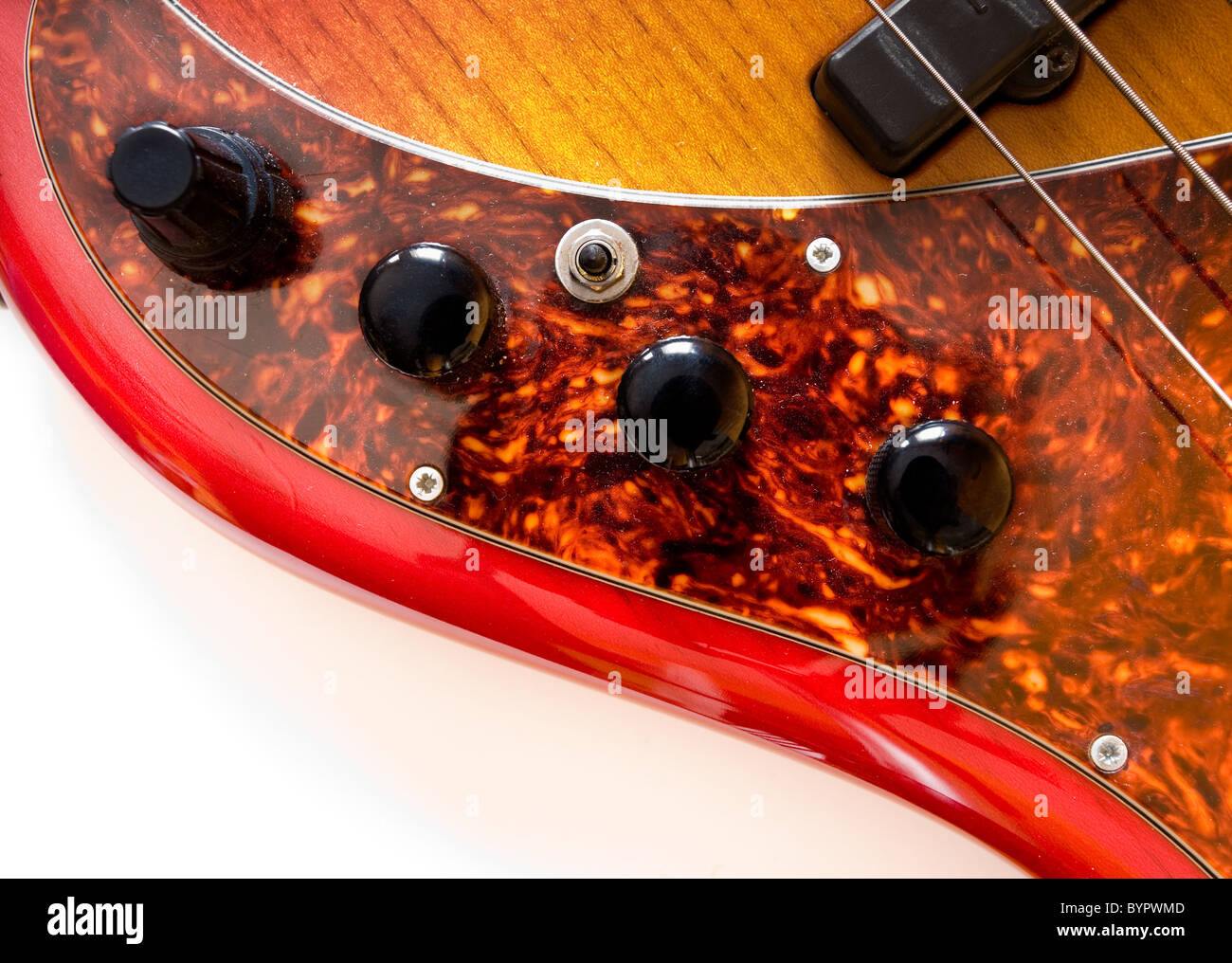 Details of bass guitar with 5 strings. Controls for volume and pickups