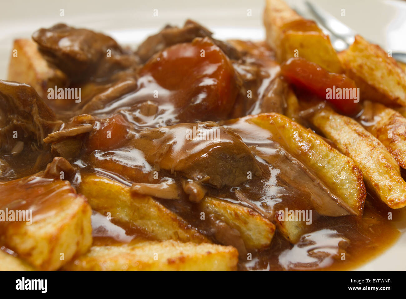 beef stew with chips or french fries close up from low perspective. Stock Photo