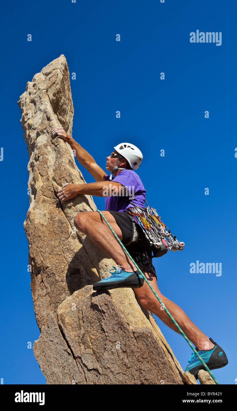 Male rock climber on the summit of a pinnacle. Stock Photo