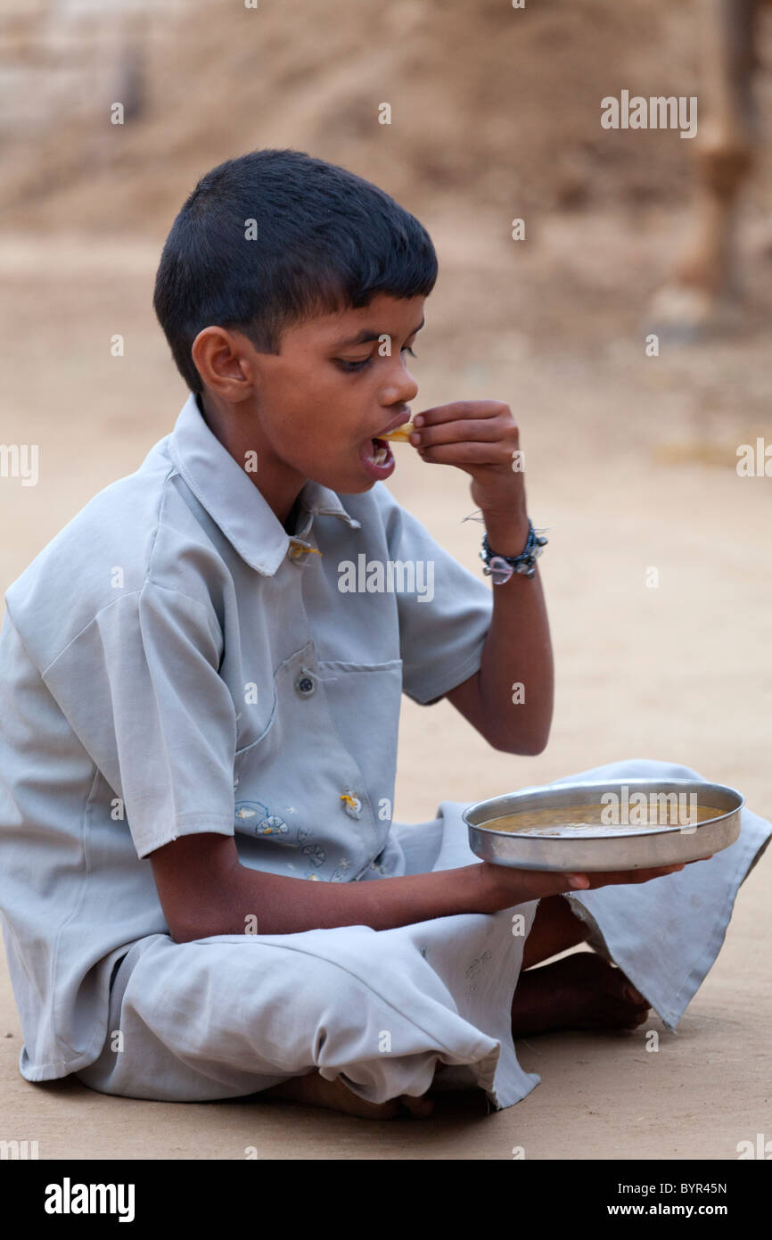 india, Uttar Pradesh, Agra young boy eating dal with western style chip ...