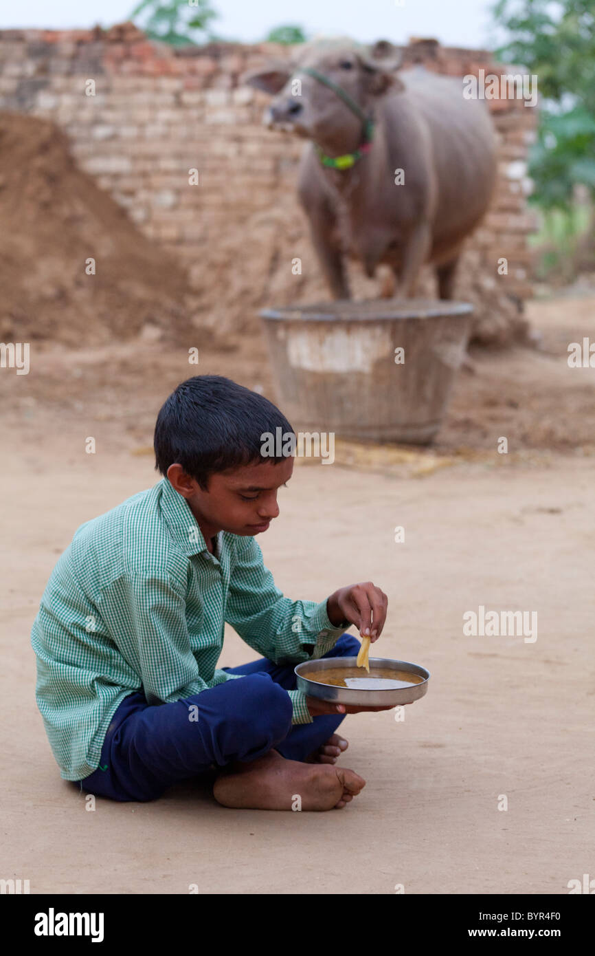 india, Uttar Pradesh, Agra young boy eating dal with western style chip Stock Photo