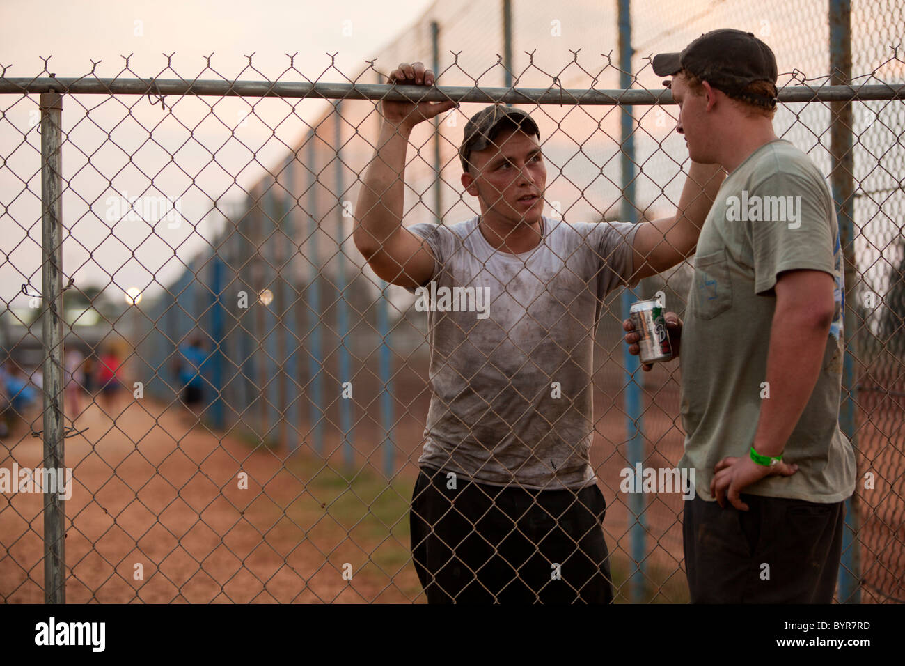 Stock Cae Ras USA, Mississippi, Gulfport, Young men talk at sunset along pit crew ...