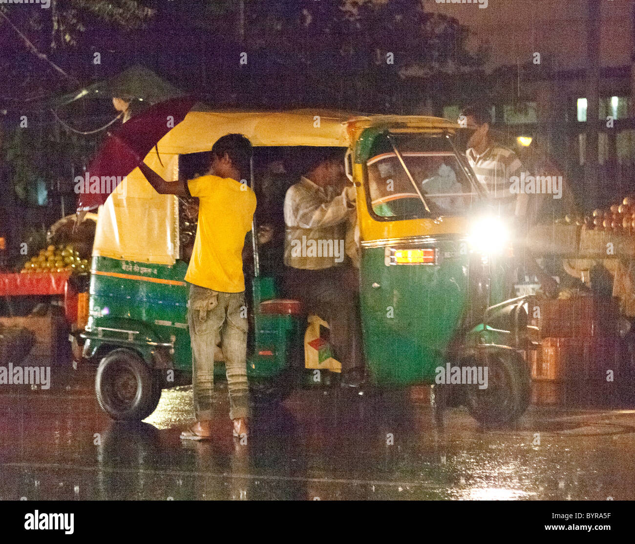 India, Uttar Pradesh, Agra, boys by rickshaw in monsoon rain Stock Photo