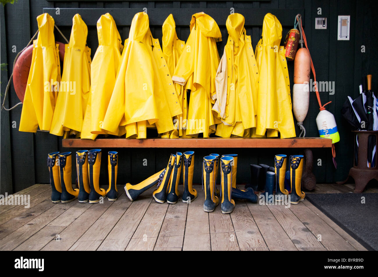 yellow raincoats and rubber boots lined up; tofino, british columbia, canada Stock Photo