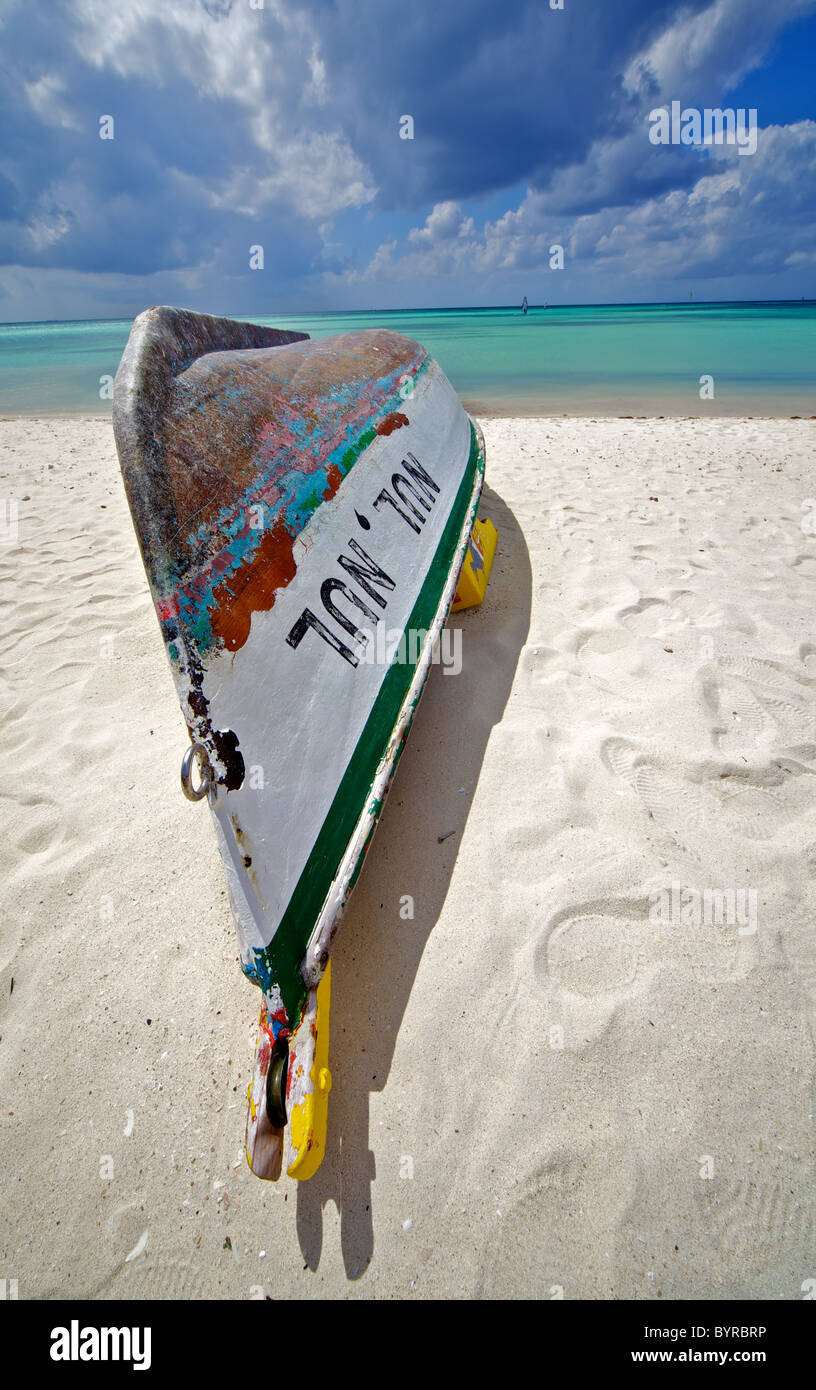 Shipwreck of a Wooden Boat on the Coastline of the Turquoise Water of the Caribbean Sea with Storm Clods on the Horizon Stock Photo
