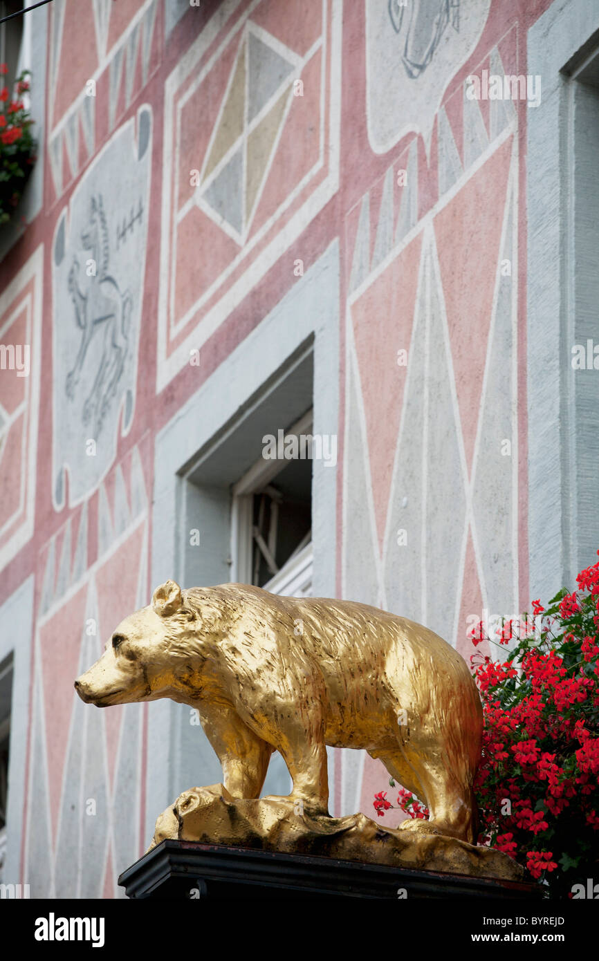 gold bear sculpture with flowers and a painted building; freiburg, germany Stock Photo