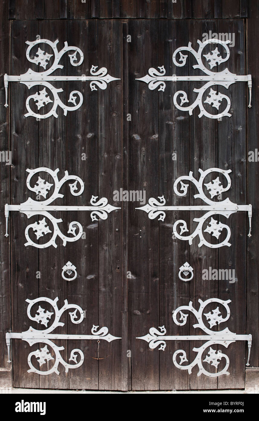 large metal decorative hinges on a weathered wooden barn door; fussen