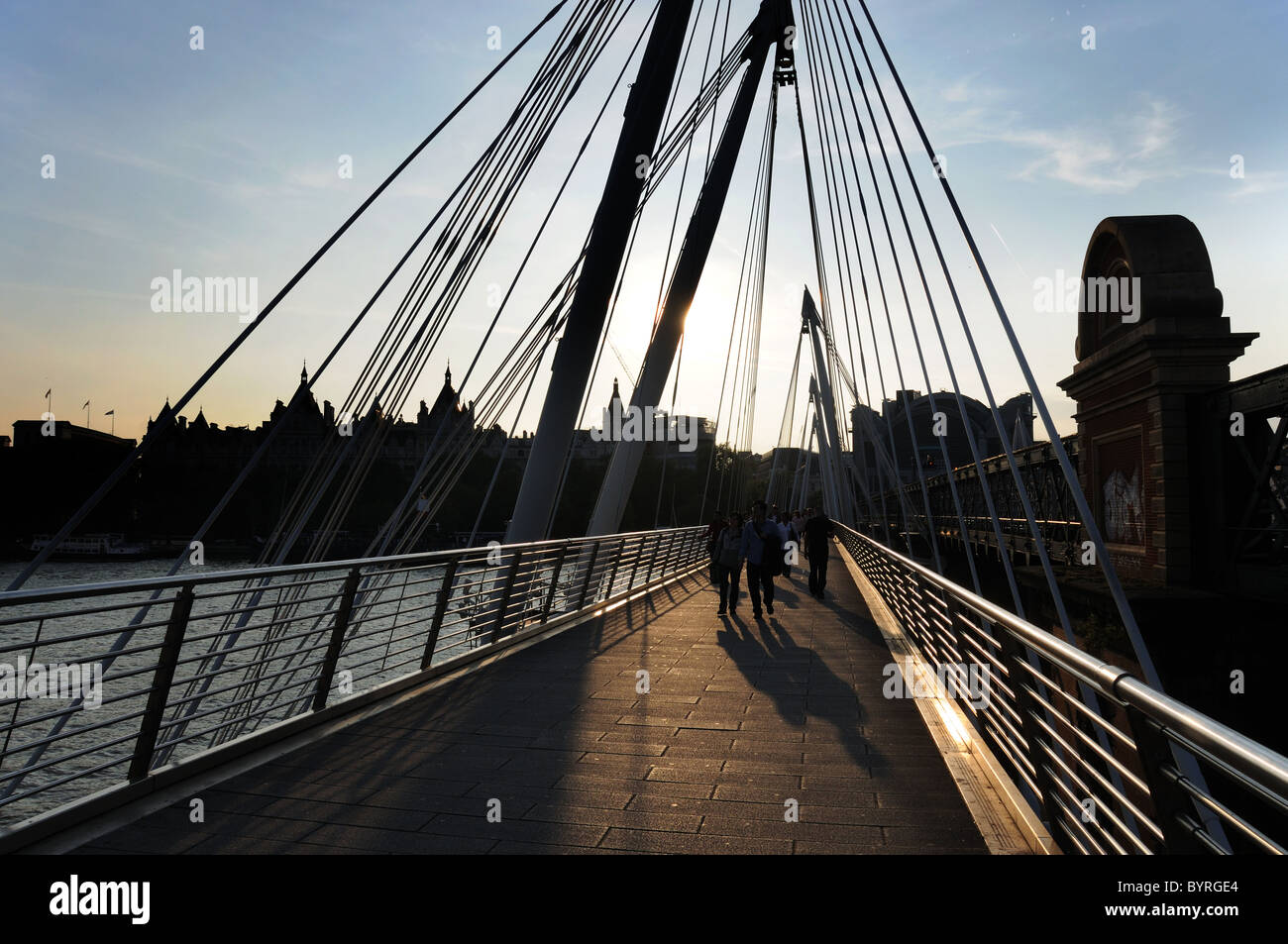 People on Golden Jubilee Bridge, London at sunset Stock Photo