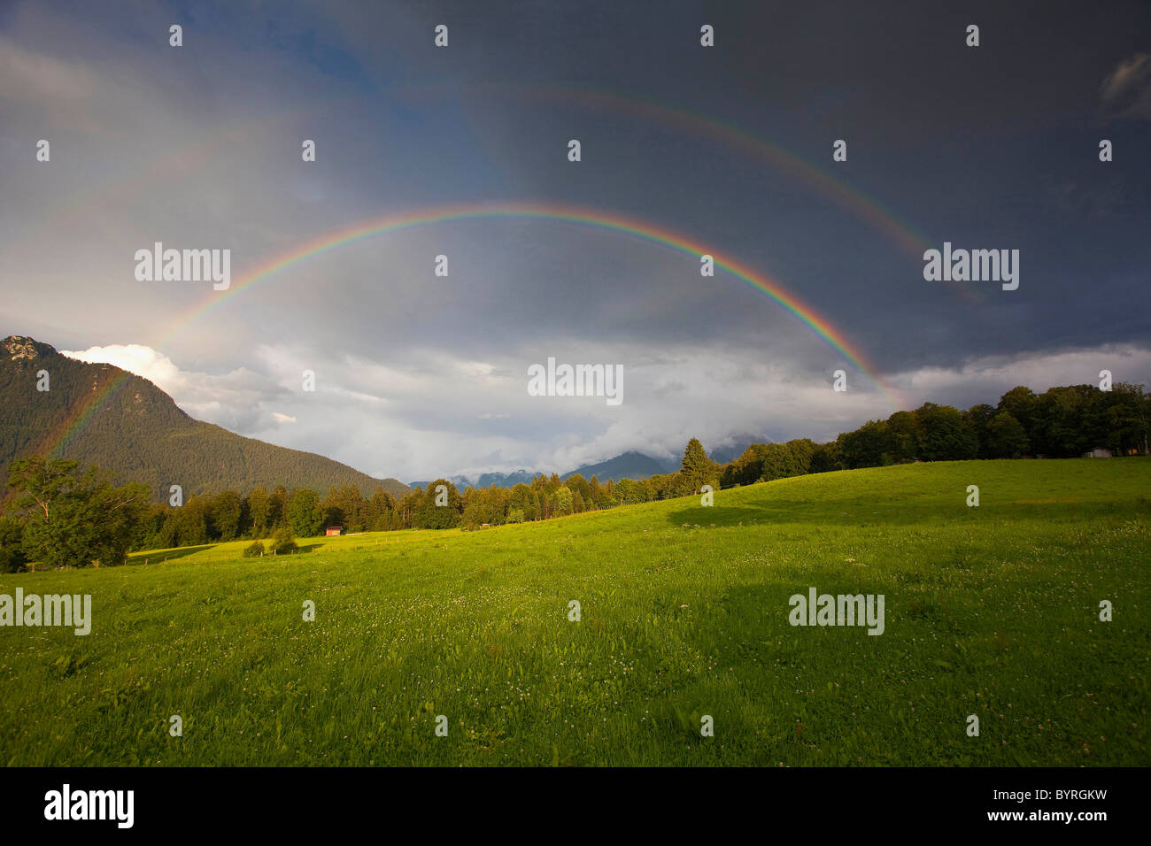 Double rainbow above meadows and woodland, Bischofswiesen, Upper Bavaria, Germany. Stock Photo