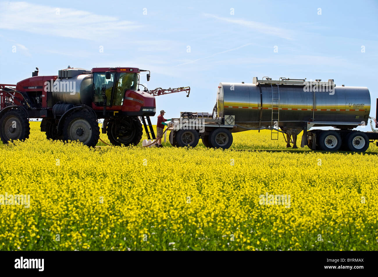 A farmer loads his high clearance sprayer with fungicide and water to spray a blooming canola crop for Sclerotinia / Canada. Stock Photo