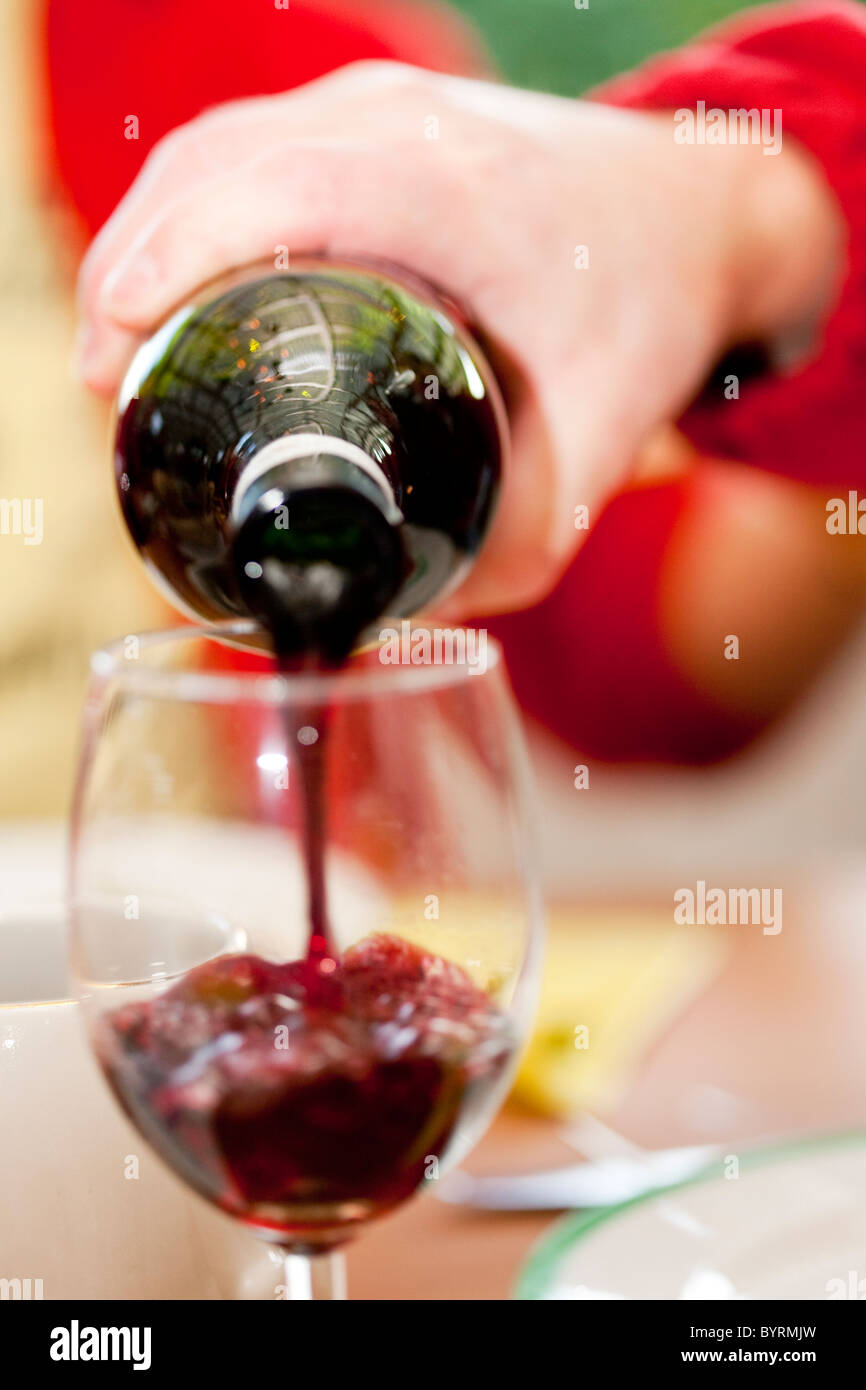 Hand pouring up redwine in a glass.Mariefred,Sweden Stock Photo