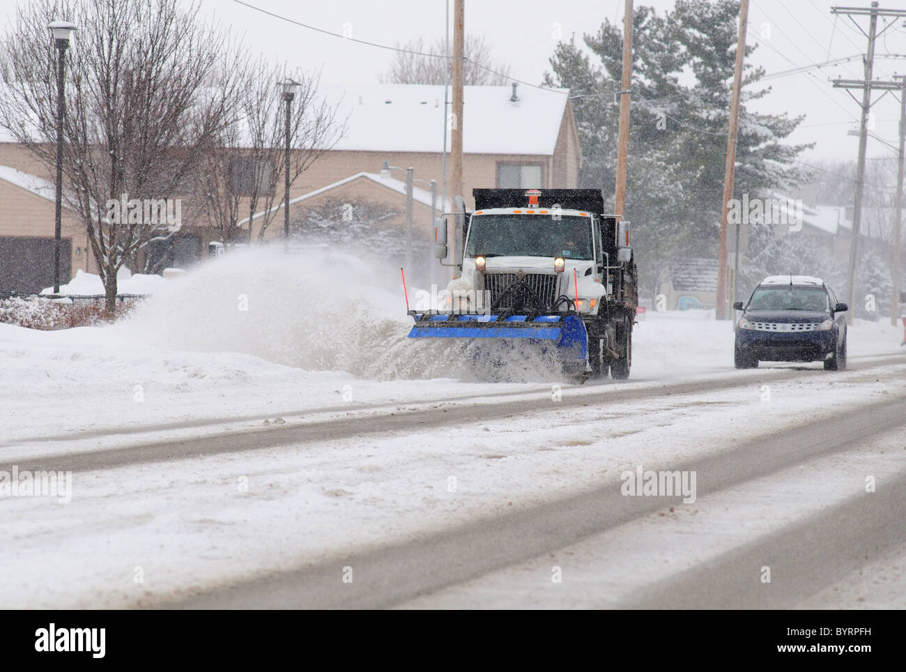 A snowplow clears a city street after a snowstorm Stock Photo