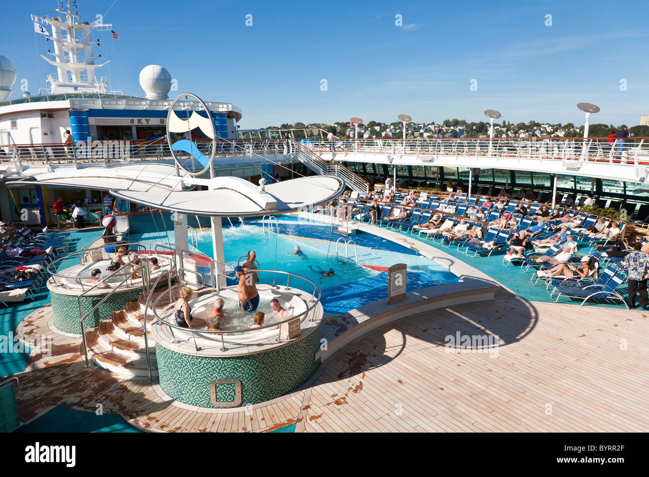 Senior men and women sit in hot tub and on lounge chairs on the deck of Royal Caribbean's Jewel of the Seas cruise ship Stock Photo