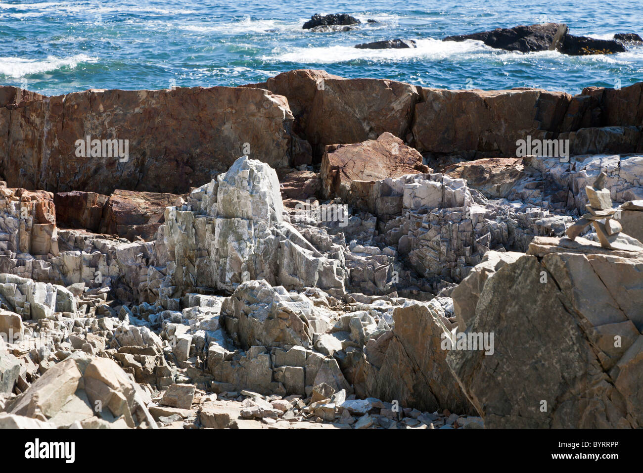 Stacked rocks form a cairn on the rocky coastline in Acadia National
