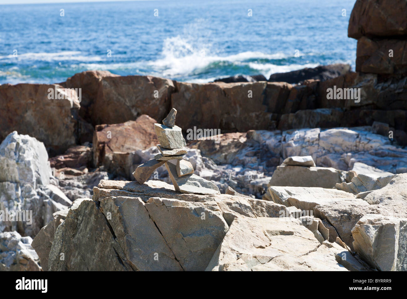 Stacked rocks form a cairn on the rocky coastline in Acadia National