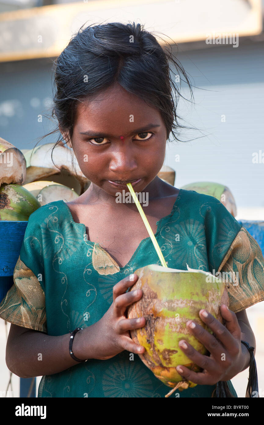 lifestyleHappy young poor lower caste Indian street girl drinking coconut water. Andhra Pradesh, India Stock Photo