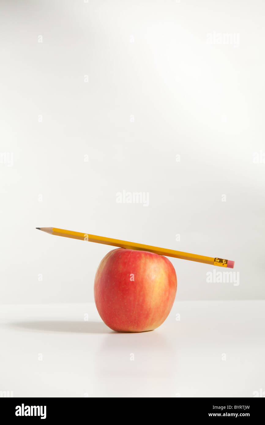 A Pencil on top of An Apple in the studio Stock Photo