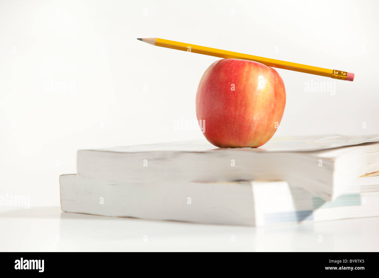 An Apple with a Pencil on a Teachers Desk Stock Photo