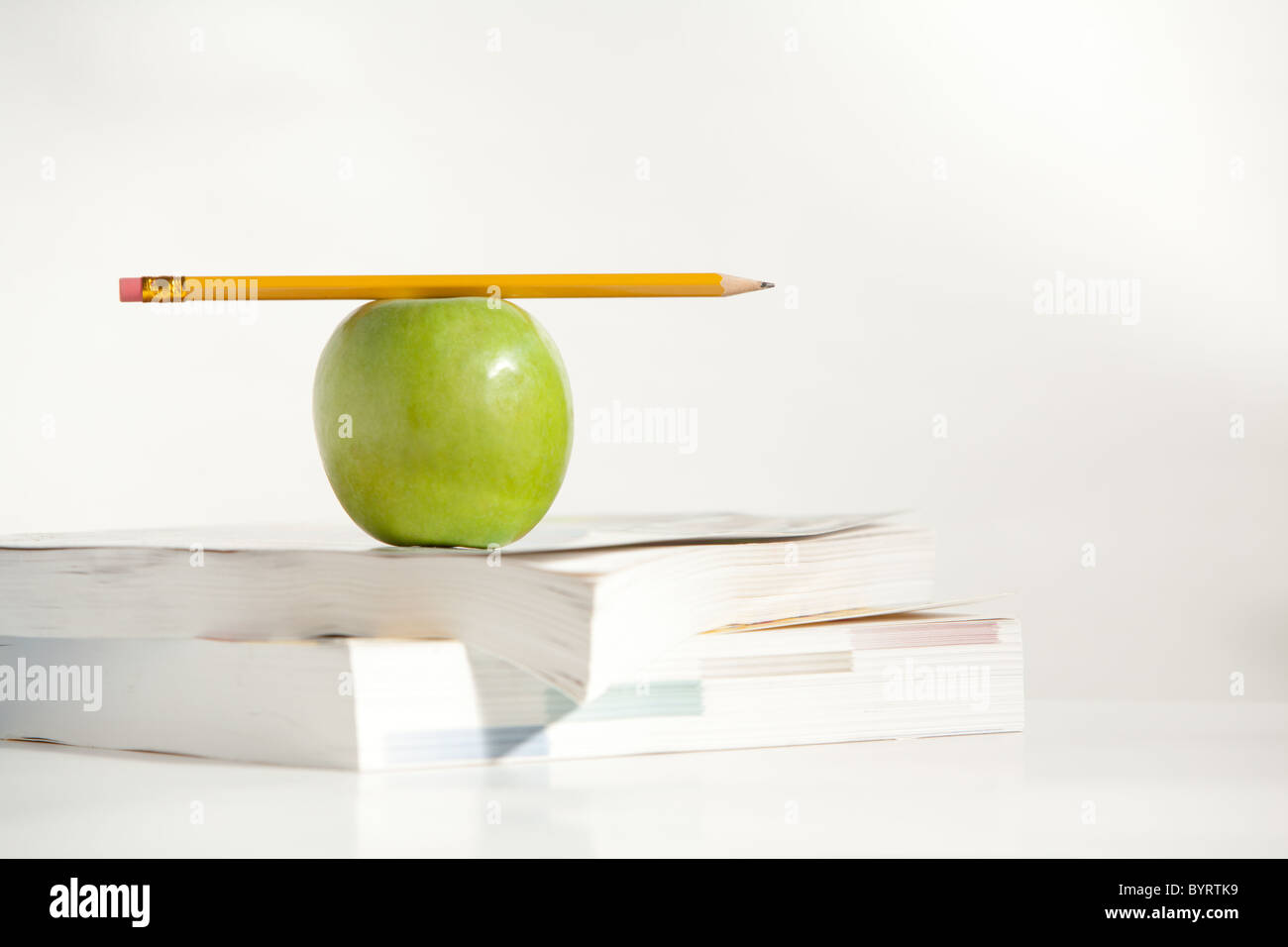 An Apple with a Pencil on a Teachers Desk Stock Photo