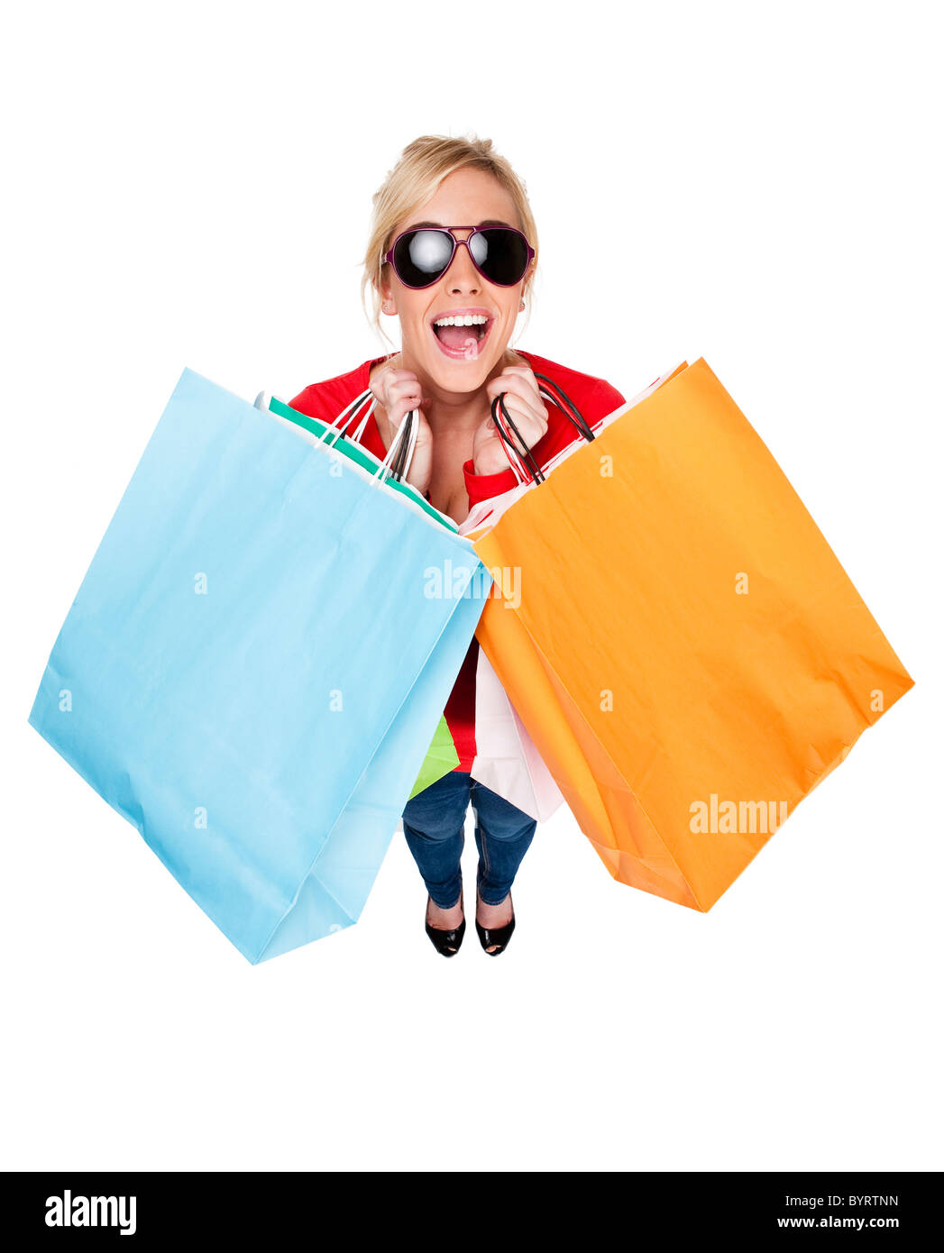 Attractive young woman wearing sunglasses looking happing holding multi-coloured shopping bags Stock Photo