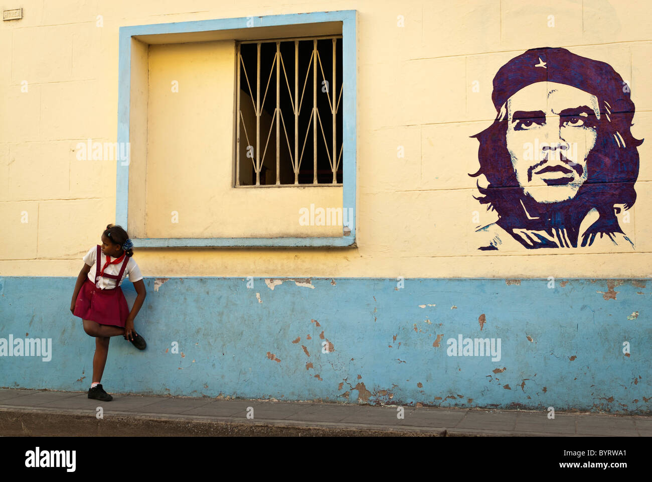 Girl in a school uniform close to a painting of Che Guevara, Camaguey, Cuba, Caribbean. Stock Photo