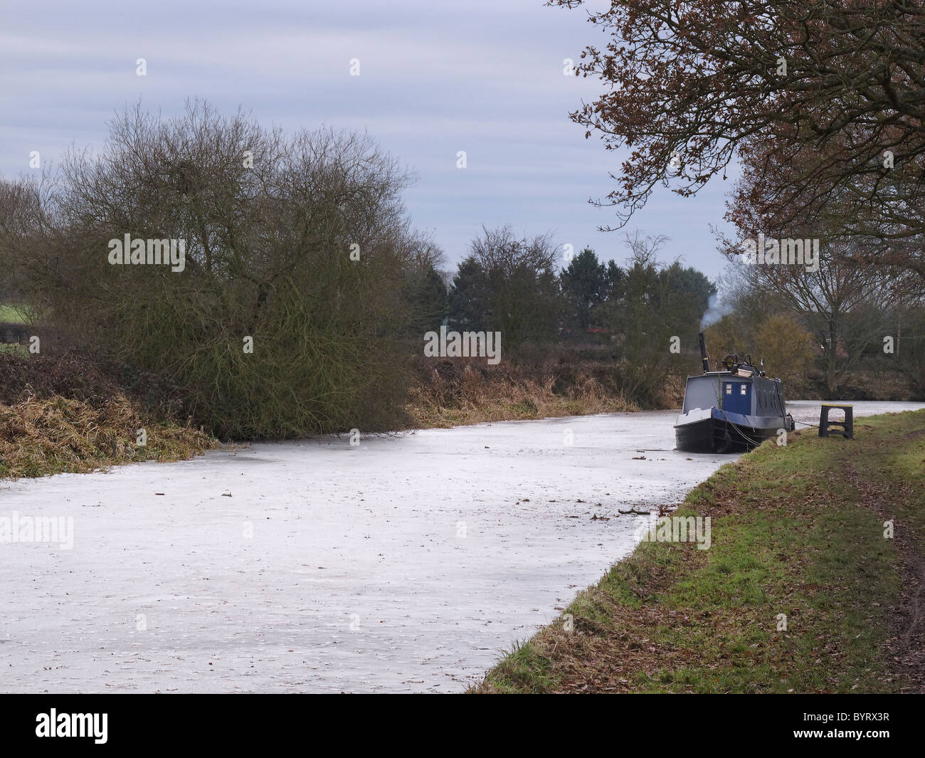 Stratford upon Avon canal near Wootton Wawen, frozen in winter, with barge. Warwickshire, UK, January 2011 Stock Photo