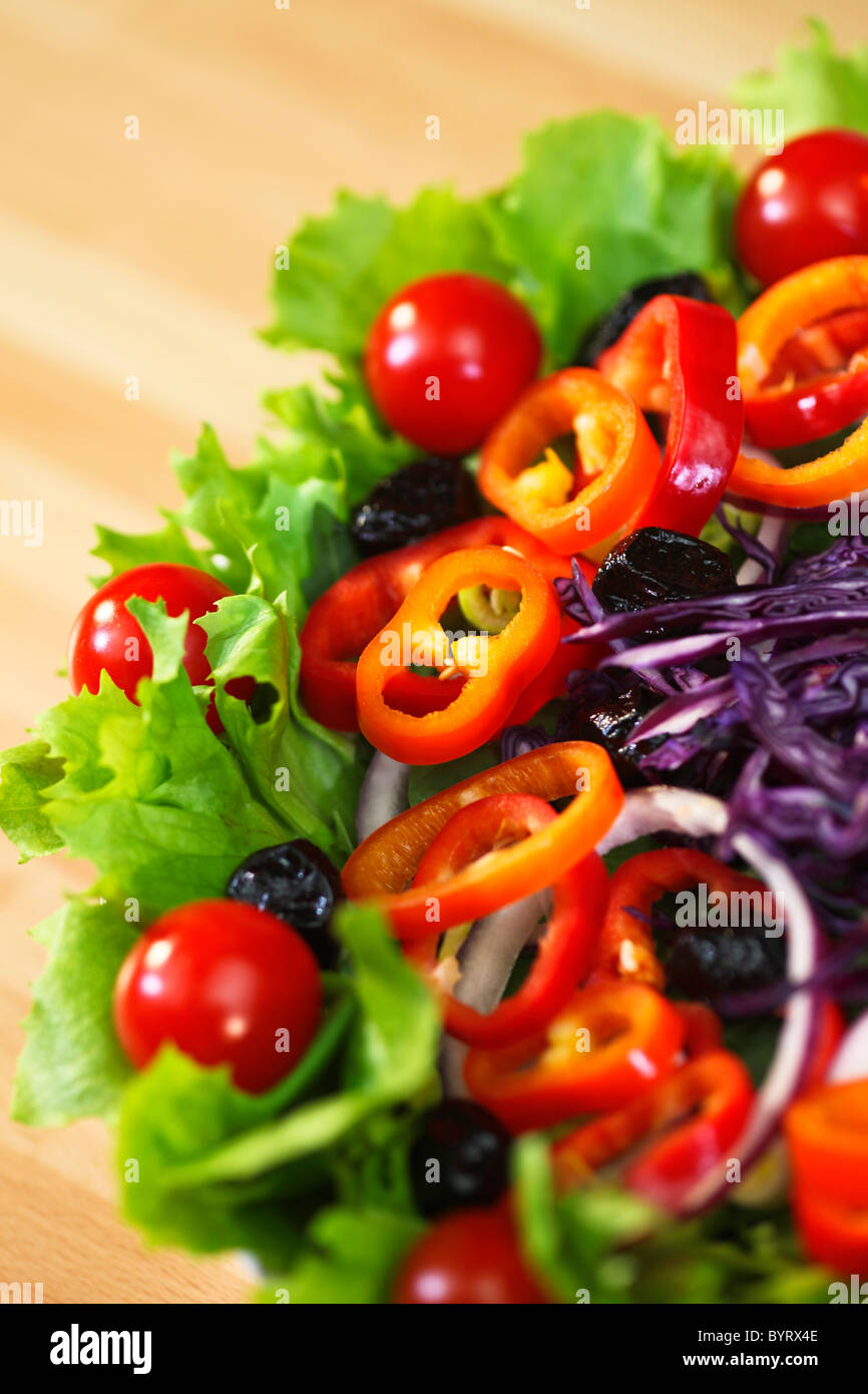 Macro photograph of fresh lettuce tomato pepper olive red onion and cabbage salad Stock Photo