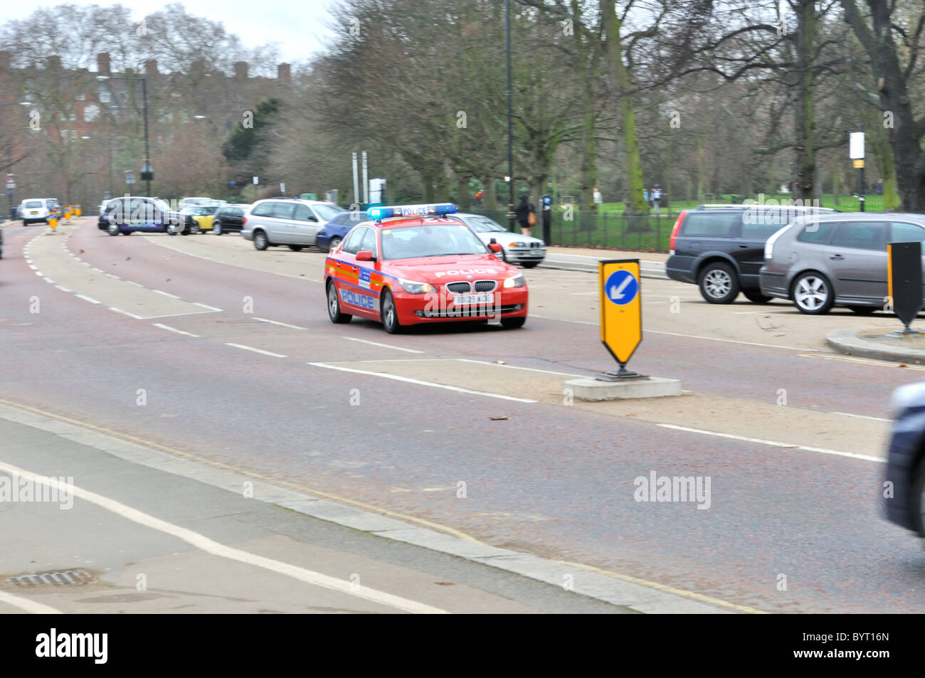 Red police car with lights on driving on london street Stock Photo