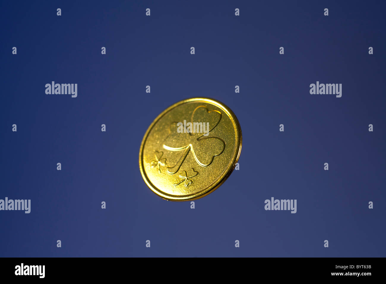 Shamrock gold coin on a colored background Stock Photo - Alamy