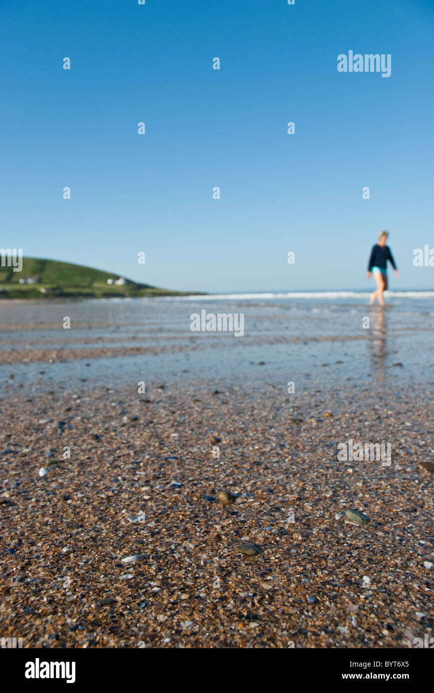 A beachcomber walks along the beach at Croyde Bay in Devon, UK. Stock Photo