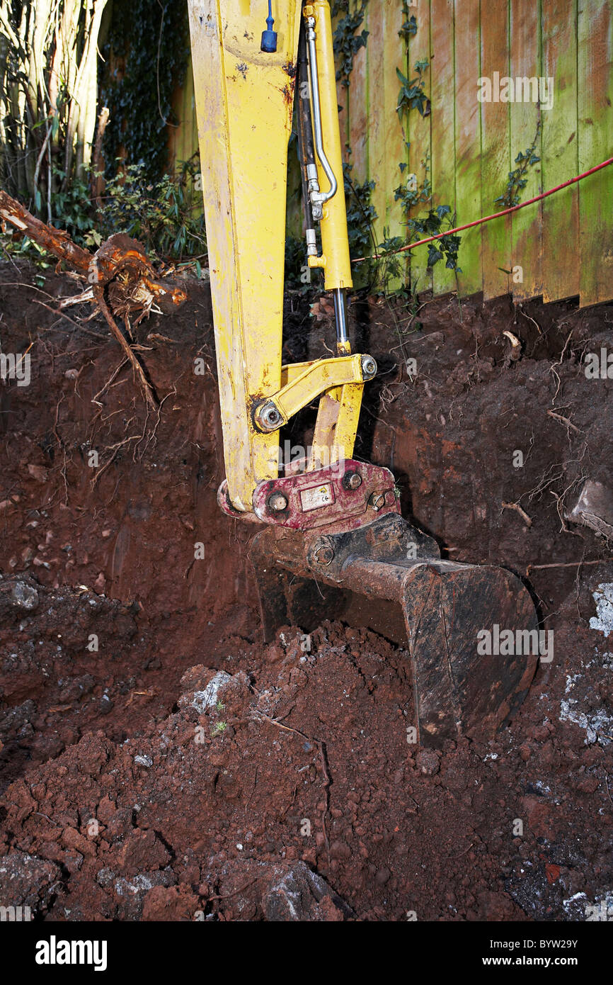 Excavating earth and preparing for an extension and patio at the back of a house. Stock Photo