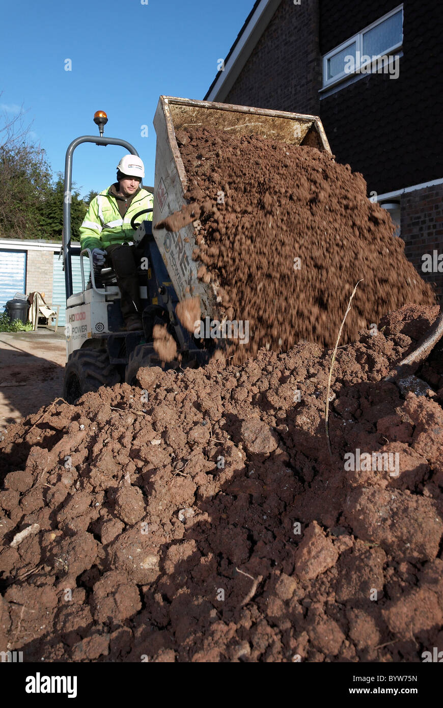 Dump truck emptying its bucket full of earth into a skip Stock Photo Alamy