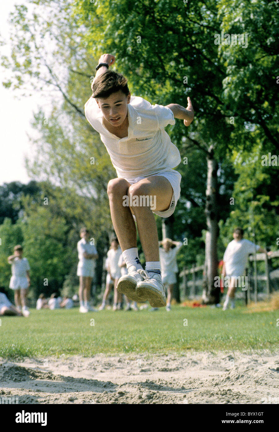 A boy jumping during school sports day Stock Photo