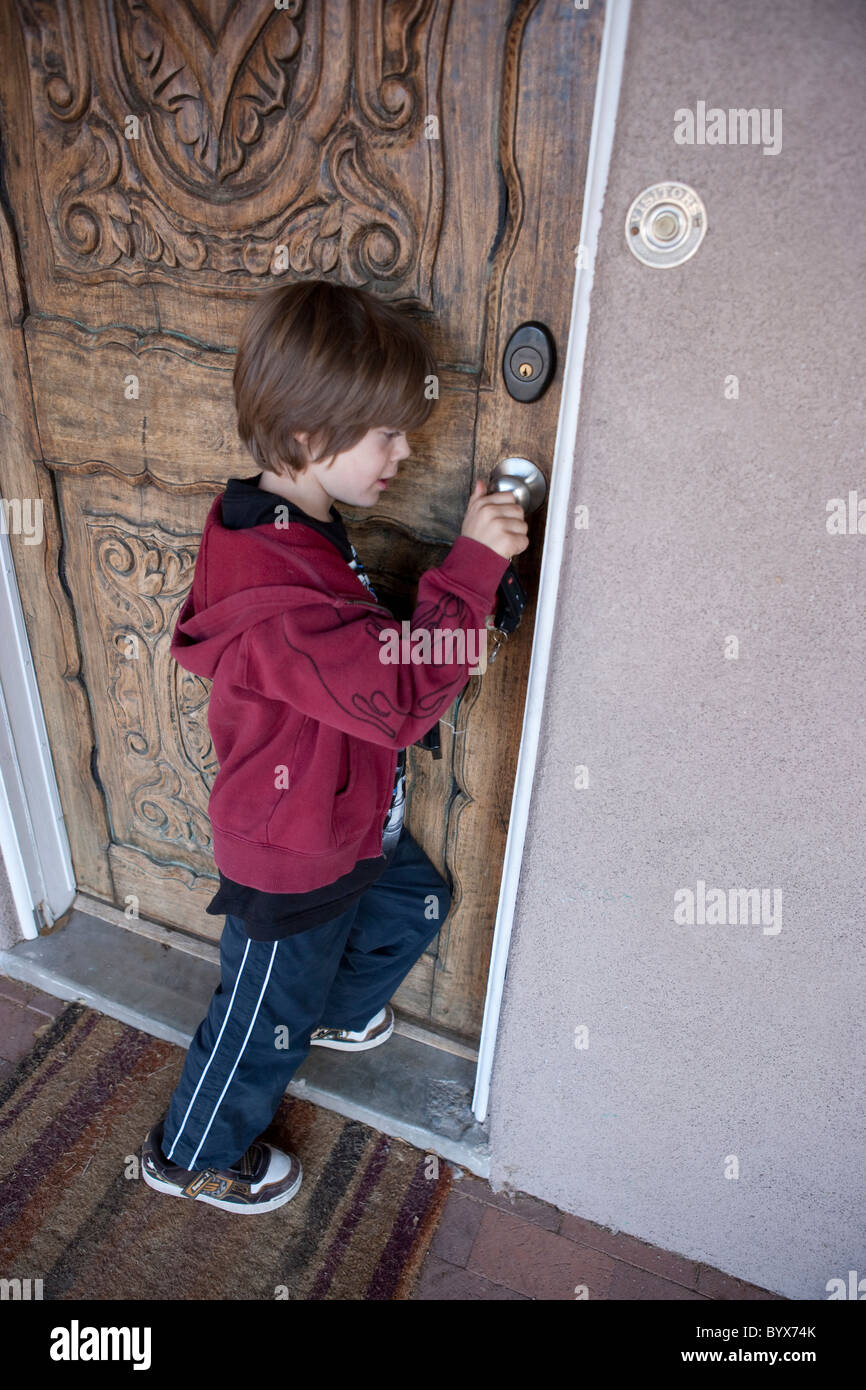 Seven Year Old Child Using A Key To Unlock And Open His