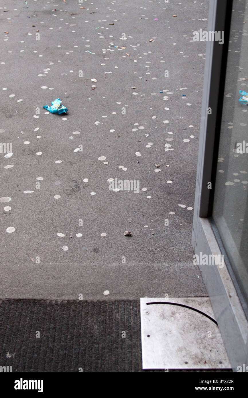 Discarded chewing gum and gigatettes on the ground outside the entrance to a public building. Stock Photo