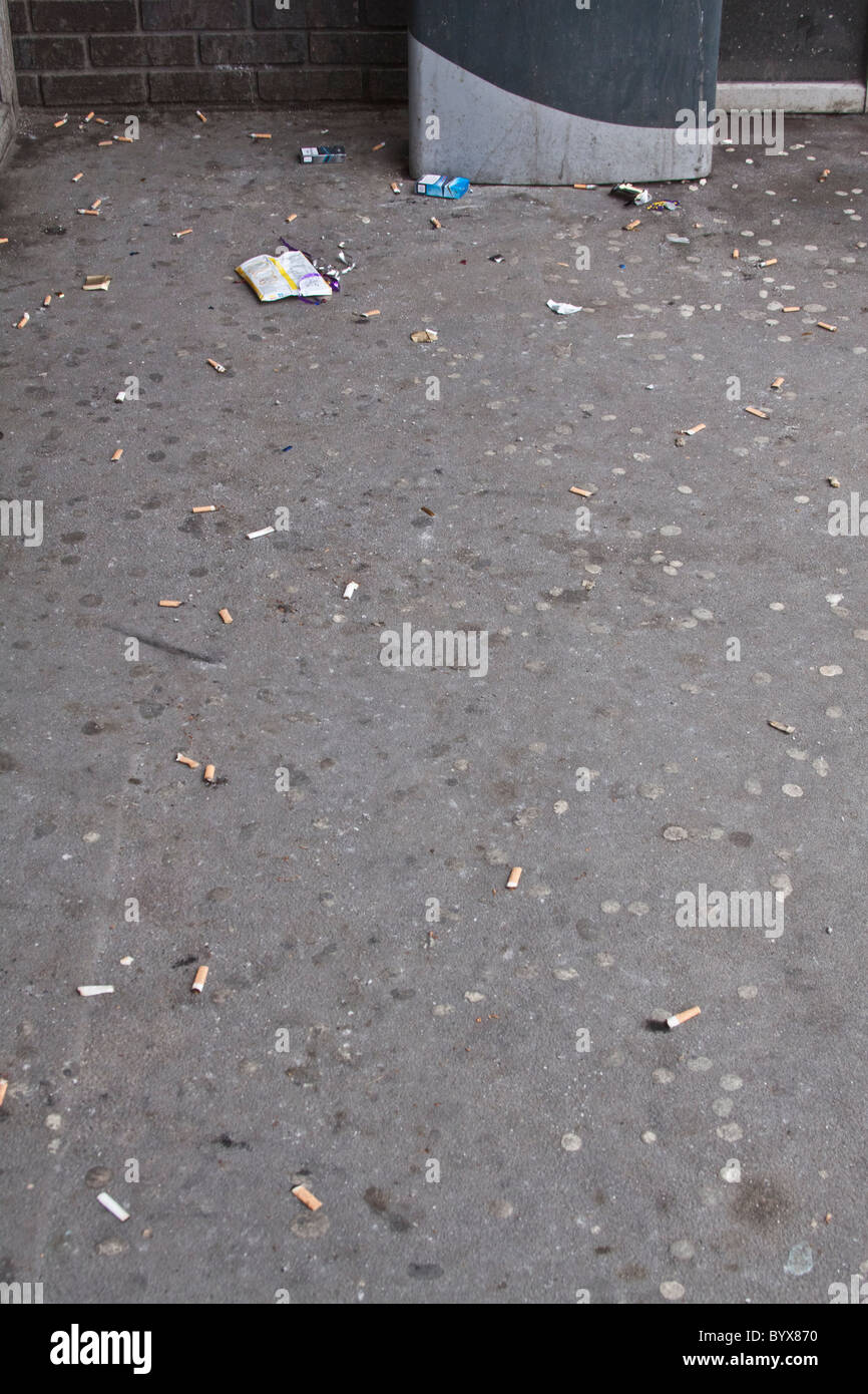 Discarded chewing gum and gigatettes on the ground outside the entrance to a public building. Stock Photo