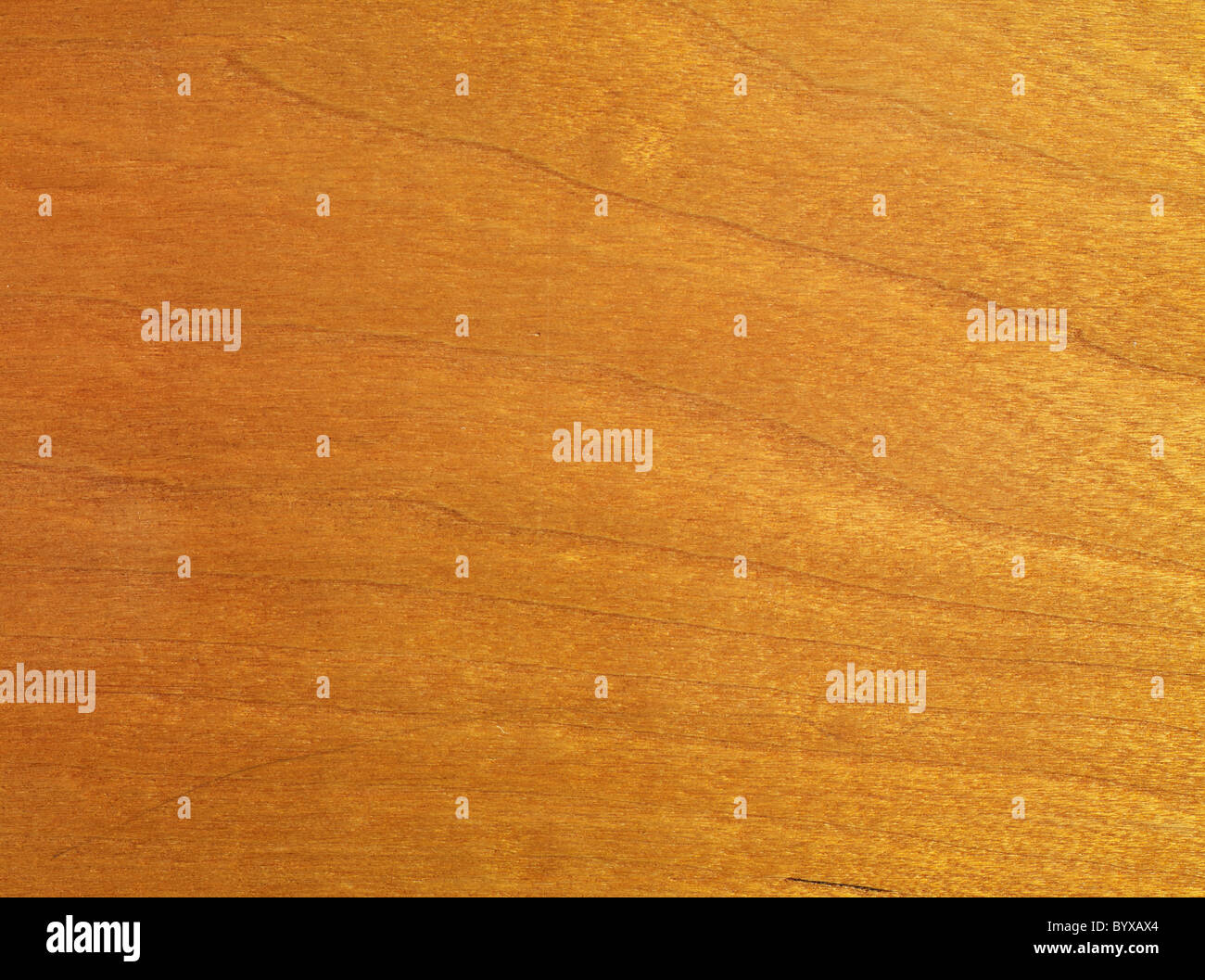 close up on a cherry wood table top with a warm sheen on the grain