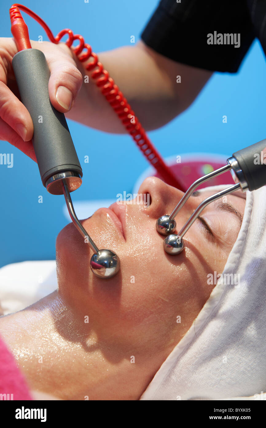 woman having a stimulating facial treatment from a therapist Stock Photo