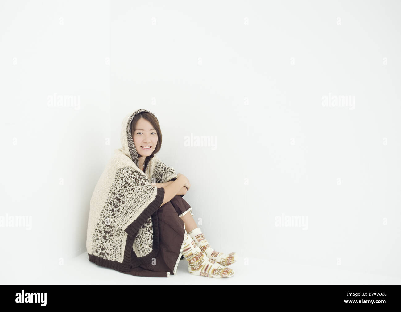Young woman sitting and hugging her knees Stock Photo - Alamy