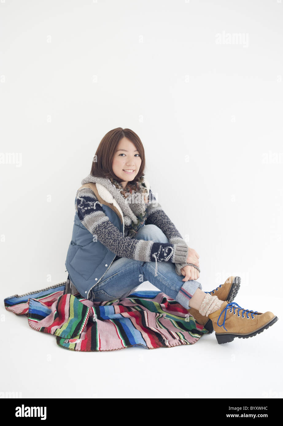 Young woman sitting and hugging her knees Stock Photo - Alamy