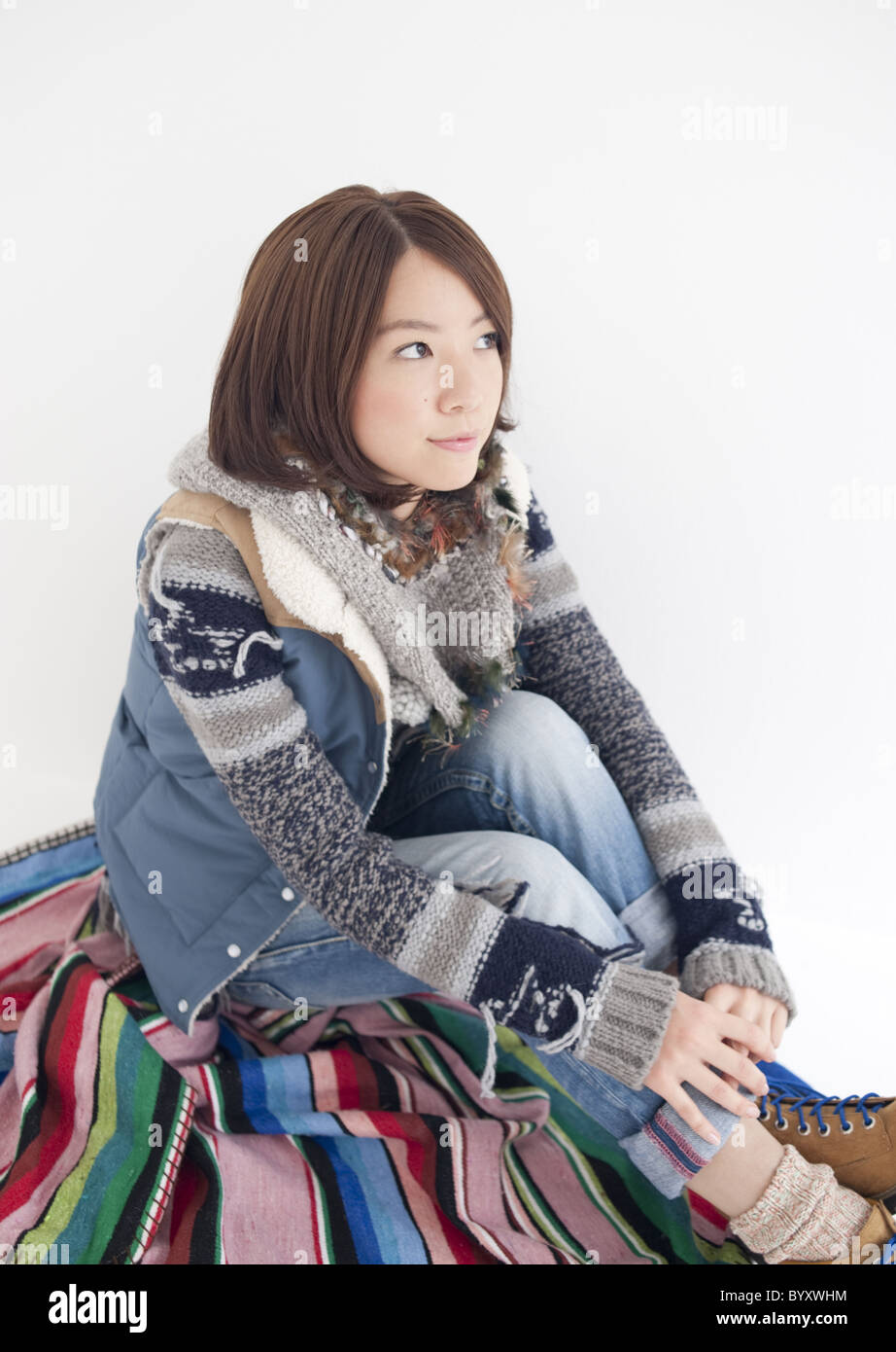 Young woman sitting and hugging her knees Stock Photo - Alamy